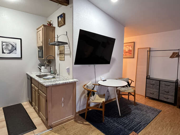 Kitchen and cafe dining area with Smart TV viewable from the bed