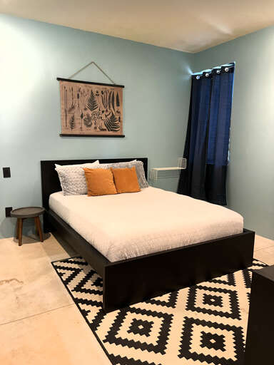 Bedroom with queen bed and workspace