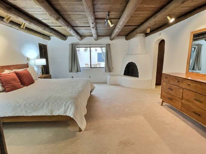 Master bedroom with vigas and fireplace