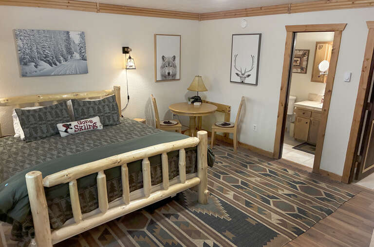 Cozy up in your rustic retreat with natural wood furnishings and mountain-inspired décor. Your private bathroom awaits just steps away, while a welcoming table invites quiet mornings with coffee.