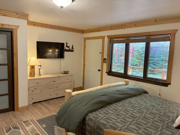 Wake up to peaceful forest views framed by warm wood accents. Your private retreat offers a cozy bed and rustic mountain charm—perfect for unwinding after a day of adventure.