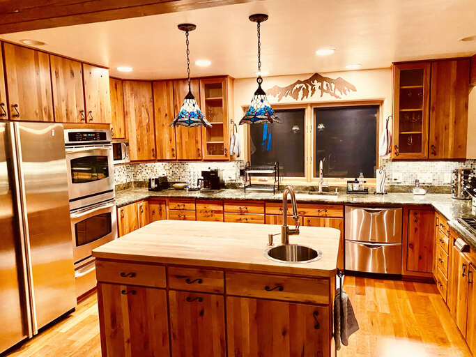 Kitchen island with bar sink and stainless appliances