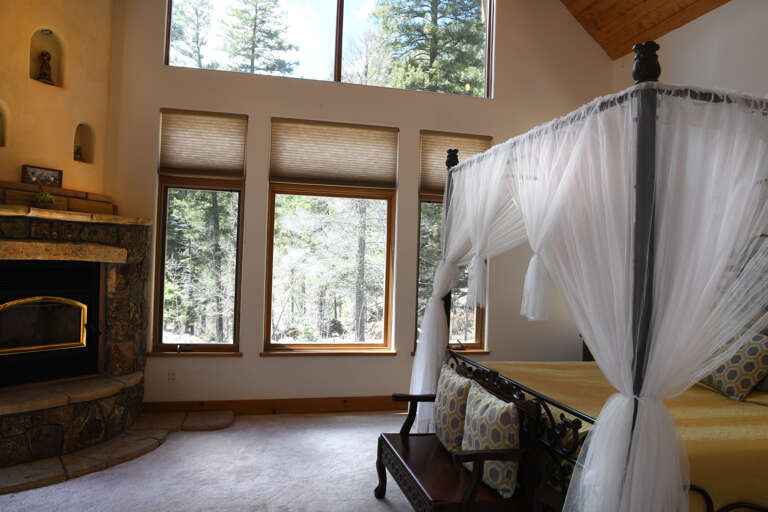King bedroom with picture windows and fireplace