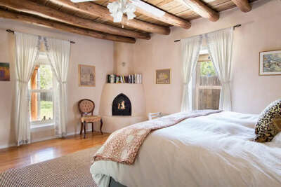 Large light-filled bedroom with kiva fireplace