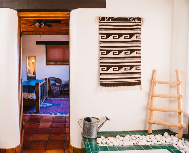 Step into your cozy bedroom through this charming doorway, where rustic tiles and authentic textiles create a warm, inviting sanctuary.