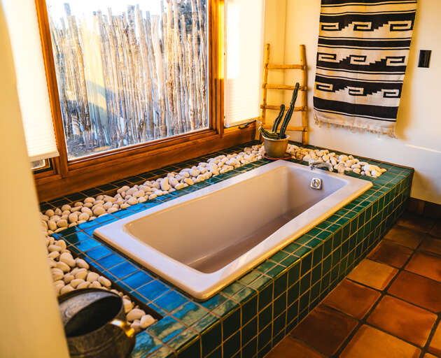 Sink into your private oasis with this stunning sunken tub surrounded by smooth river stones and beautiful tilework.