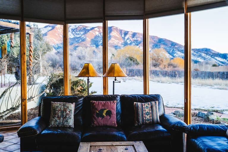 Sink into this leather sofa and let the breathtaking mountain vista fill your senses through floor-to-ceiling windows.