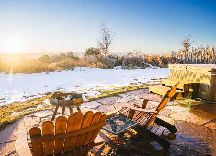 Unwind in your private hot tub as golden winter light bathes the snowy landscape around you.