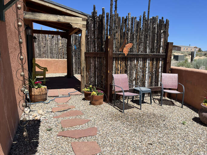 Back patio courtyard with private hot tub area behind the fence off the primary bedroom
