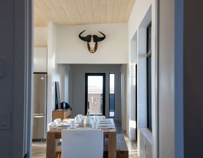 Gather around your rustic dining table beneath striking décor, where morning coffee and evening meals become memorable moments.