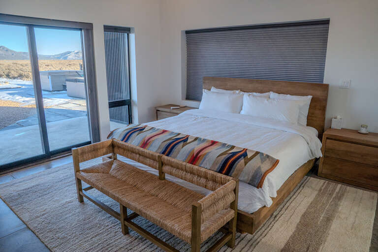 Sink into crisp white linens while enjoying stunning mountain views from your private bedroom retreat.