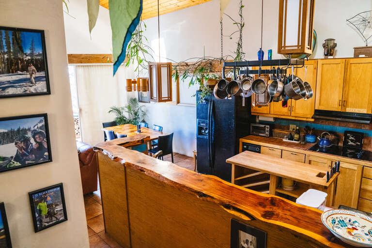 Cook your favorite meals in this charming kitchen featuring warm wood finishes, hanging cookware, and a welcoming island for gathering.