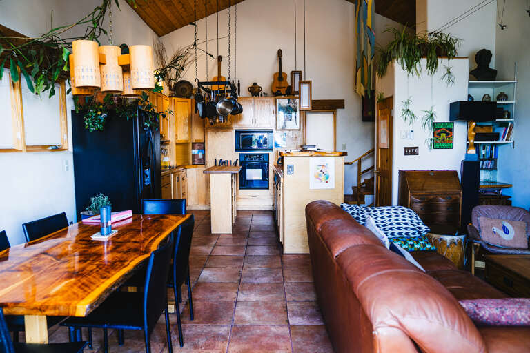 Unwind in your artistic open-concept retreat with rustic wood beams, leather seating, and a fully equipped kitchen perfect for creative souls.