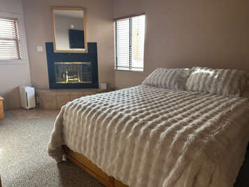 Drift off peacefully in your cozy bedroom, wrapped in soft bedding while the fireplace adds warmth and ambiance to your restful nights.