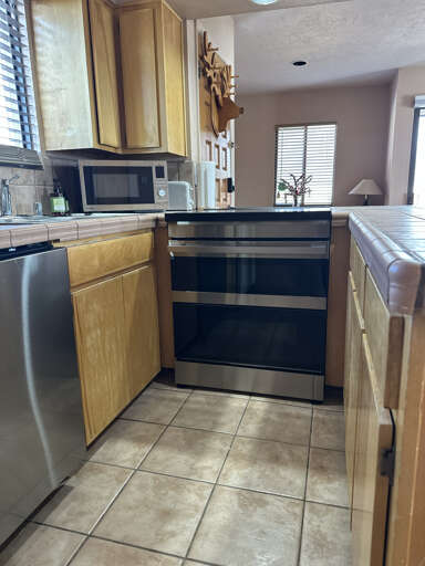 Your fully equipped kitchen awaits with warm wood cabinets, stainless steel appliances, and everything you need to create memorable meals together.