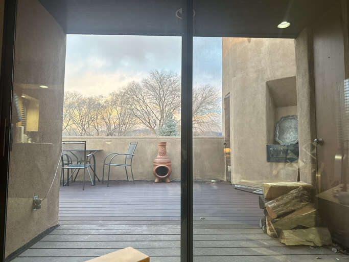 Step onto your private balcony where modern seating awaits beneath open skies and leafless trees.