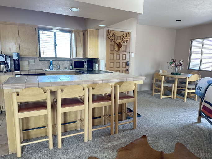 Your spacious kitchen features tiled counters, full appliances, and a breakfast bar where you'll gather for memorable meals and morning coffee.