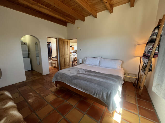 Rustic charm meets comfort in your serene bedroom, where exposed wood beams and terra cotta tiles create authentic warmth for peaceful nights.