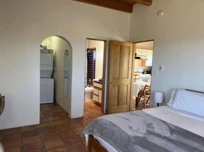 Your spacious bedroom features rustic exposed beams and opens to a charming arched bathroom and bright kitchenâperfect for comfortable extended stays.