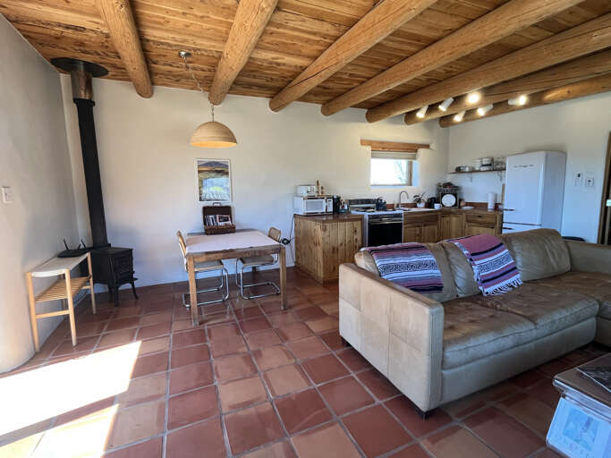 Relax in your rustic adobe retreat with exposed wooden beams and cozy fireplace warmth.