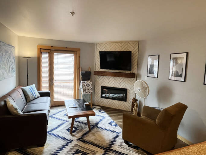Unwind in your bright, modern living room with a cozy fireplace, smart TV, and stylish seatingâthe perfect retreat after a day in the mountains