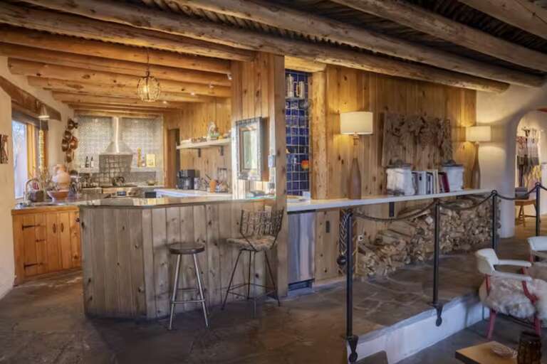 Picture yourself gathering in this warm alpine kitchen, where rustic wood beams frame a spacious island perfect for morning coffee or aprÃ¨s-ski meals together.