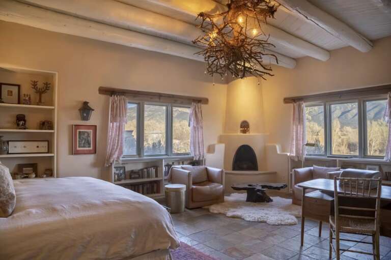 Relax in your spacious bedroom with vaulted ceilings, a cozy kiva fireplace, and stunning mountain views through large windows that fill the room with natural light.