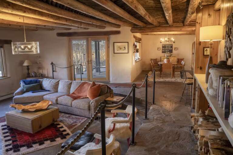 Step into your cozy mountain retreat with rustic wooden beams, plush seating, and warm lighting that invites you to unwind after a day of adventure.