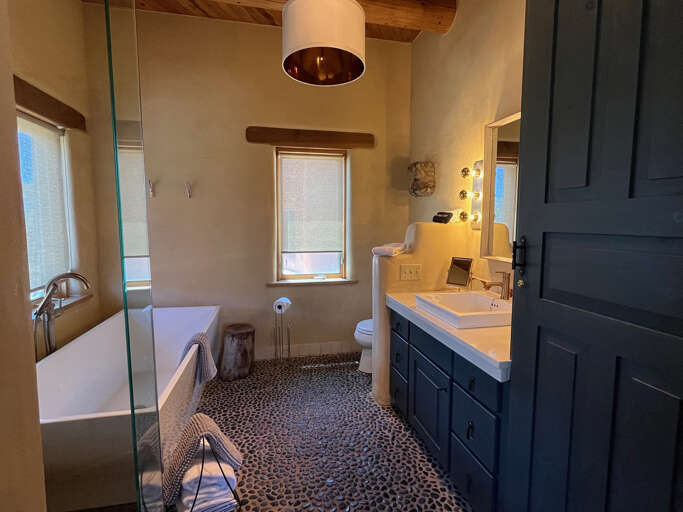 Step into your private spa-like sanctuary with vaulted ceilings, a soaking tub, and elegant pebble floors.