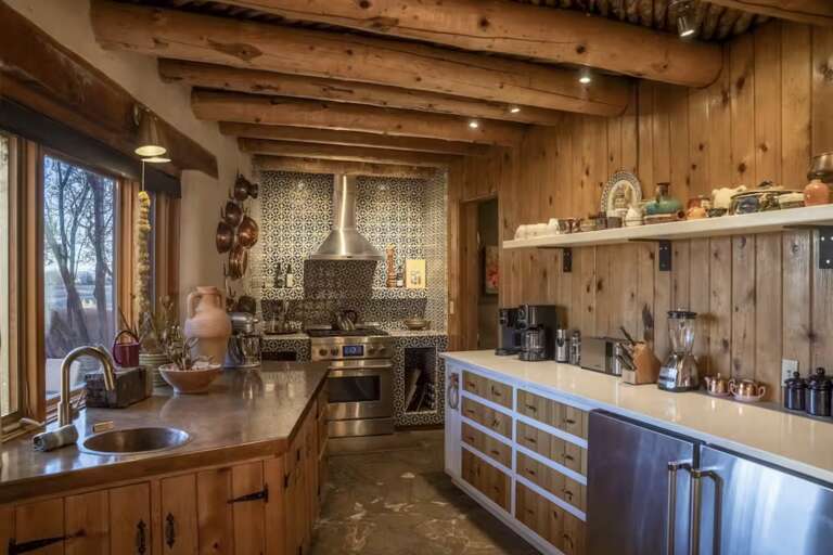 Step into a stunning rustic kitchen with beautiful wood beams, stylish tilework, and modern appliances ready to help you craft memorable meals during your stay.