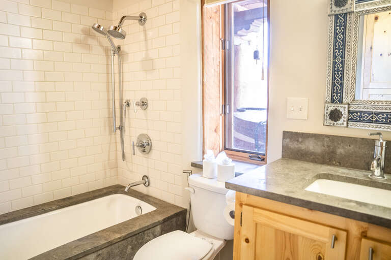 Refresh and unwind in your private bathroom, featuring a classic subway tile tub-shower combo, natural light streaming through the window, and a clean vanity ready for your morning routine.
