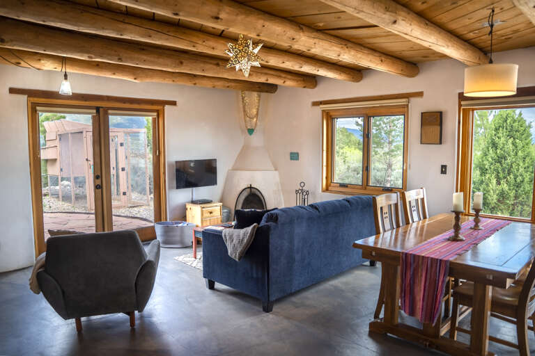 Unwind in your open-concept living and dining space, where natural wood beams, a cozy fireplace, and mountain views through every window create the perfect setting for gatherings and relaxation.