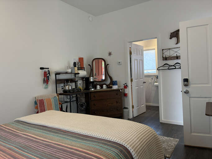 Your cozy bedroom features charming vintage touches and thoughtful amenities, with an open en-suite bathroom just steps from your bed.