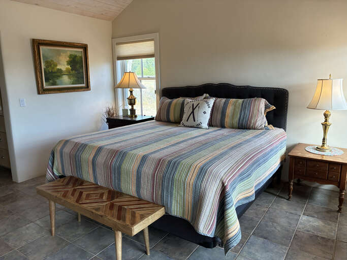 Settle into your restful retreat with a plush bed dressed in soft linens and framed by warm lamplight. Your cozy sanctuary invites you to unwind after a day of adventure.