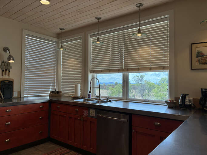 Your gourmet kitchen features warm cherry cabinetry, sleek countertops, and stunning mountain views through expansive windows—perfect for preparing meals while soaking in the scenery.