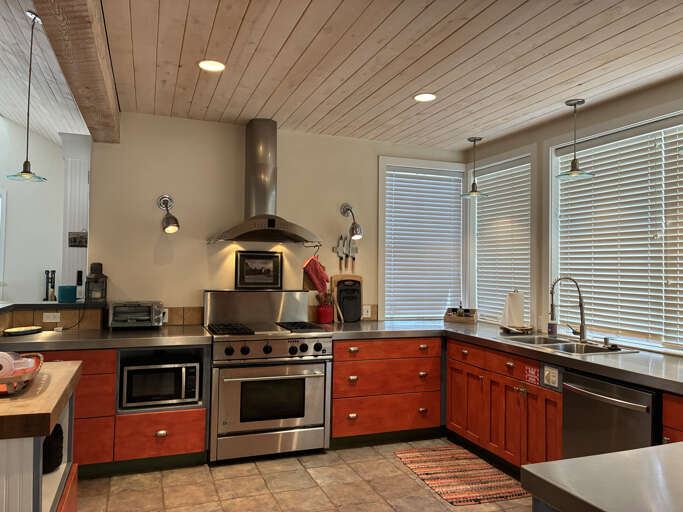 Cook your favorite meals in this fully-equipped kitchen, featuring quality appliances and warm wood cabinetry bathed in natural light.