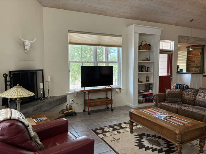 Sink into the leather seating and unwind in this bright living space, where wood ceilings and charming décor create a warm, inviting atmosphere for your mountain retreat.