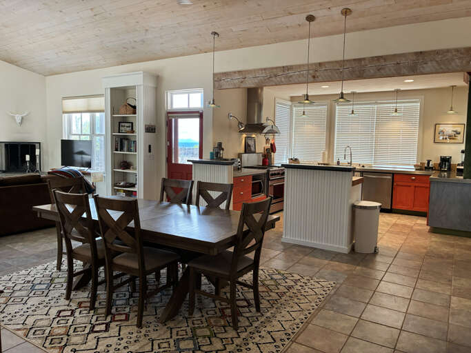 Gather at the farmhouse table or whip up your favorite meal in this open kitchen, where natural light fills the space and bright sea views peek through the windows.