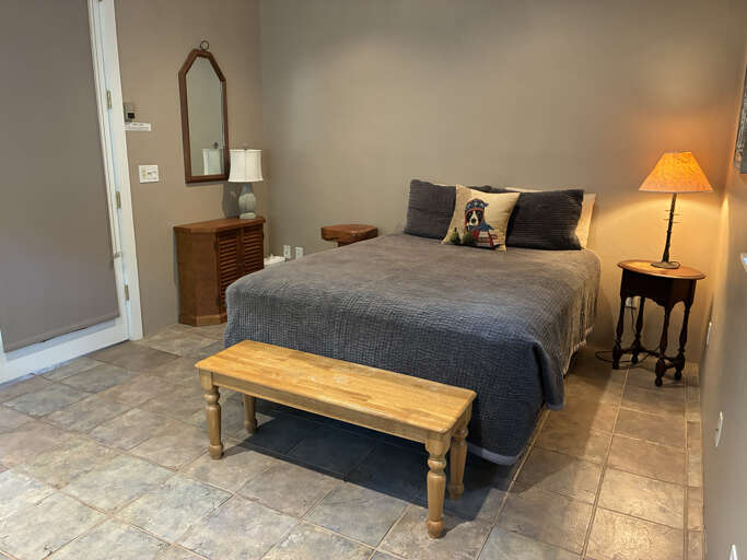 Unwind in your spacious bedroom with cozy textured bedding, warm ambient lighting, and charming rustic touches that create a peaceful retreat after a day of adventure.