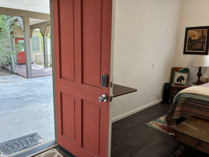 Step inside your cozy bedroom where thoughtful touches await. The warm space opens to a covered patio, blending indoor comfort with outdoor charmâperfect for your peaceful getaway.