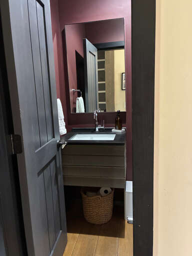 Step into your stylish powder room, where rich burgundy walls and a modern floating vanity create an intimate, boutique-like retreat for refreshing throughout your stay.
