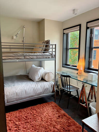 Your cozy bunk bedroom awaits with soft linens and natural light streaming through large windows. A convenient desk and reading lamp create the perfect corner for planning your adventures.
