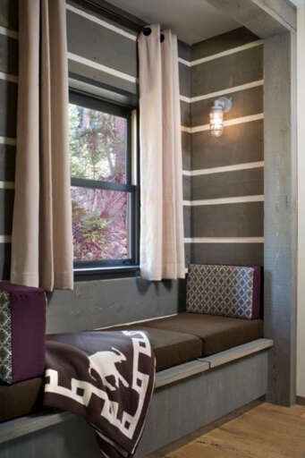 Curl up in your own cozy reading nook with built-in bench seating, soft pillows, and a natural woodland view through the windowâperfect for quiet mornings with a book.