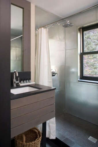 Step into your sleek private sanctuary with modern touches. Natural light streams through the window while you prepare for your day, enjoying the clean lines and contemporary design of your personal space.