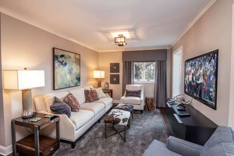 Living Room Offers Wall-Mounted HD Smart TV and Plenty of Seating