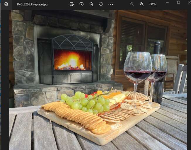 Stone Fireplace With Fire, Wine Glasses, And A Cheese Platter On A Wooden Table Stone Fireplace With Fire, Wine Glasses, And A Cheese Platter On A Wooden Table