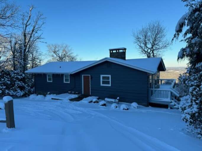 Snow-draped House Beneath Blue Skies