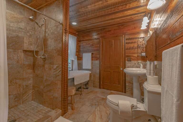 Main floor bathroom with tiled shower and clawfoot bathtub