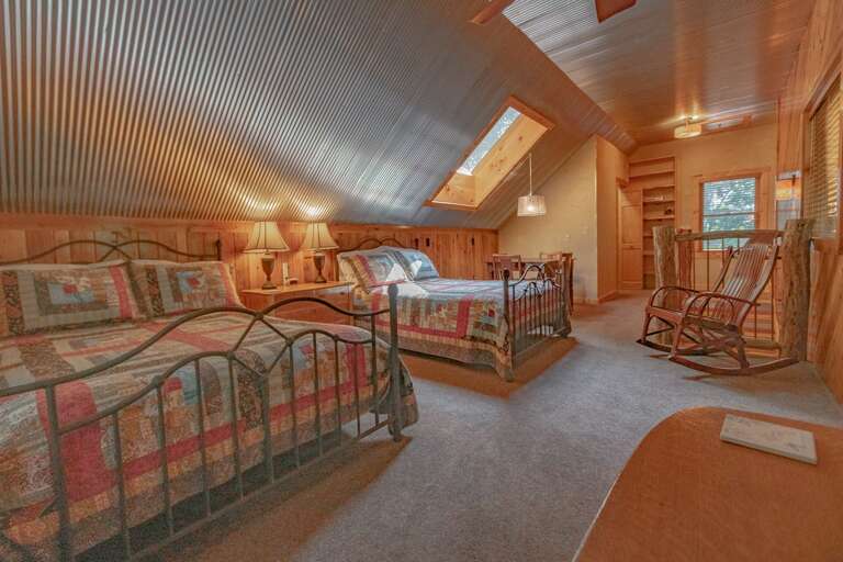 Upper Level Sleeping Area with Two Double Beds, Rocking Chair, Game Table, and Skylights