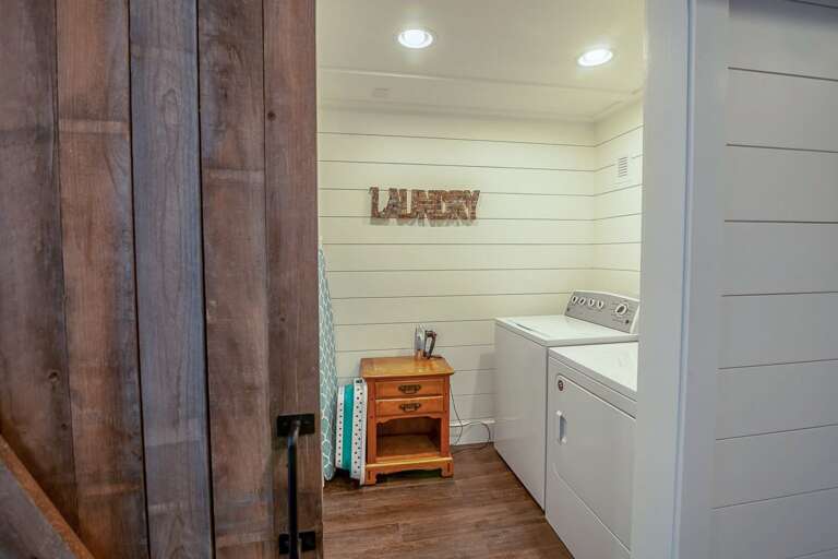 Laundry facilities with barnwood sliding door